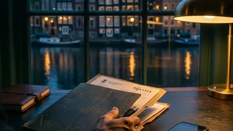 An evidence folder and phone beside a window overlooking an Amsterdam canal